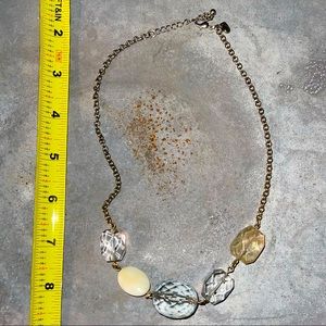 Gold-toned necklace with light amber, light sea-blue, clear and cream beads.